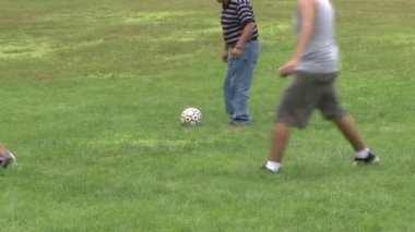 Bir piknikte bir parkta futbol oynayan çocuklar