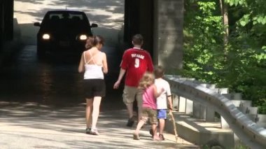 Bir aile geliyor bir araba ile küçük bir köprünün altında hiking