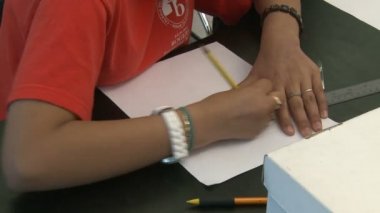 İlköğretim Okulu öğrenci kağıttan satırları silme