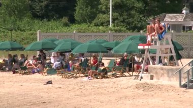 Yeşil plaj şemsiyeleri bir cankurtaran stand yanında bir çizgi