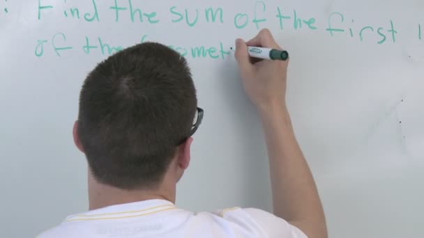 Estudante escrevendo em quadro branco na frente da aula (3 de 3 ) — Vídeo de Stock