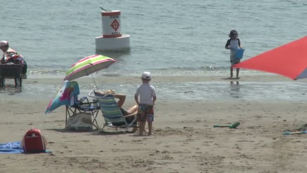 Osób korzystających z plaży pod parasolami. (1 z 4) — Wideo stockowe