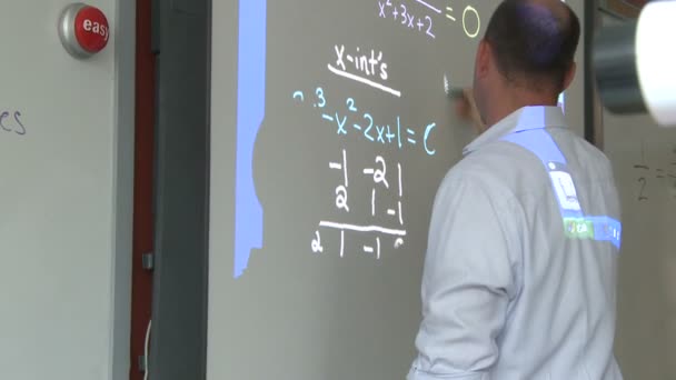 Teacher working on board in front of class — Stock Video