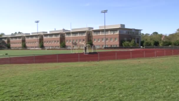 En la parte trasera de una escuela mirando un campo de deportes vacío — Vídeo de stock