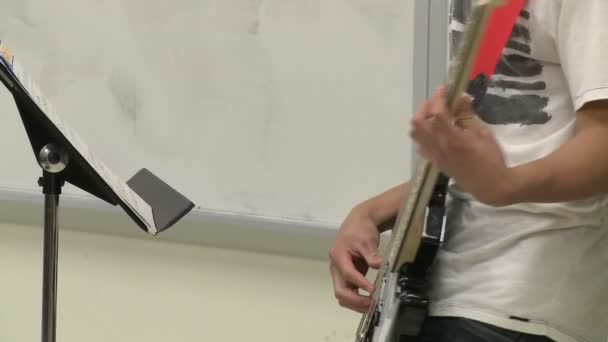 Estudante tocando guitarra na aula de música — Vídeo de Stock
