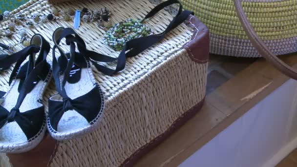 Een paar sandalen weergegeven op een rieten mand — Stockvideo