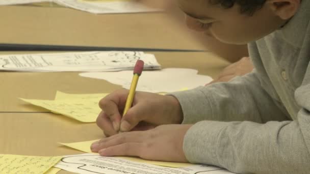 Estudantes da escola de gramática trabalhando em papéis em sala de aula (11 de 11 ) — Vídeo de Stock