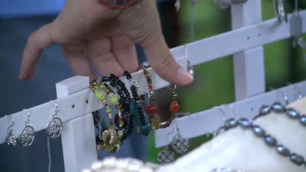 En regardant des bracelets à une foire artisanale . — Video