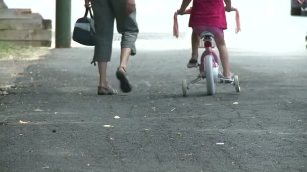 Madre caminando junto al niño en bicicleta con ruedas de entrenamiento — Vídeos de Stock