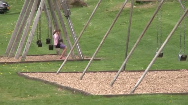 Самотня дівчина гойдаються на swingset (1 з 2) — стокове відео