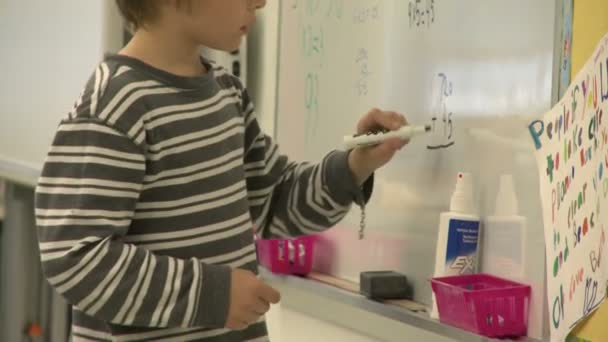 Grammar school student writing on board with a marker (2 of 3) — Stock Video