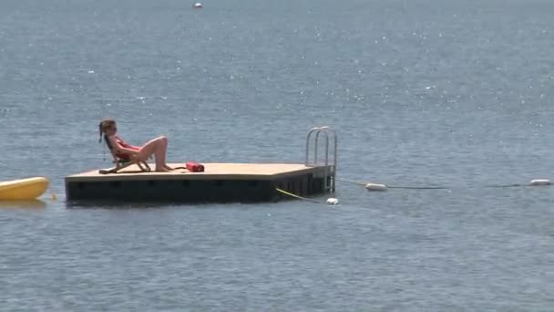 Vrouw zonnebaden op een vlot met een rubber dinghy gebonden aan het (2 van 2) — Stockvideo