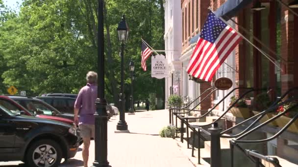 Люди сидять перед магазинів з американськими прапорами — стокове відео