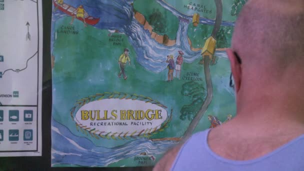 Una pareja mirando un mapa de senderos para Bulls Bridge Recreational Facility (2 de 2 ) — Vídeo de stock