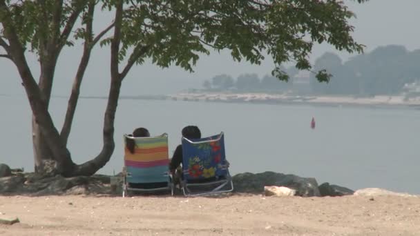 两个人坐在折叠椅上看着水。(1 of 2) — 图库视频影像