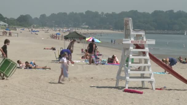 Pessoas que gostam da praia sob guarda-chuvas. (4 de 4) ) — Vídeo de Stock