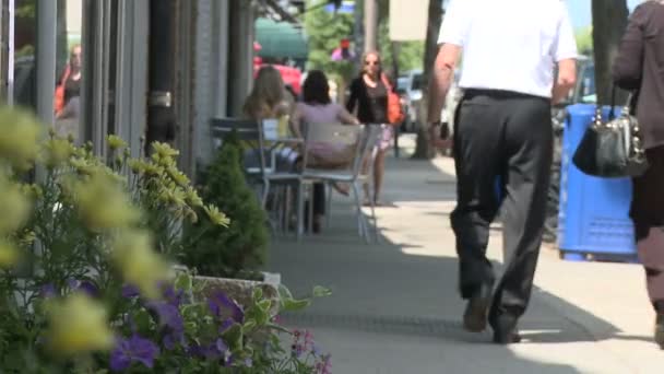 Mensen wandelen door venster in langs trottoir — Stockvideo