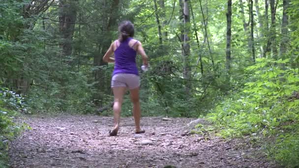 Uma garota caminhando e pulverizando repelente de insetos em si mesma — Vídeo de Stock