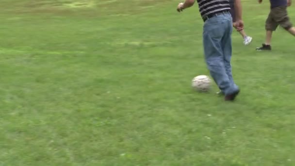 Хлопчики грають футбол у парку на пікнік — стокове відео