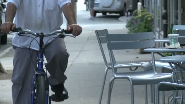 Hombre en bicicleta a caballo por el lado paseo cafetería — Vídeos de Stock