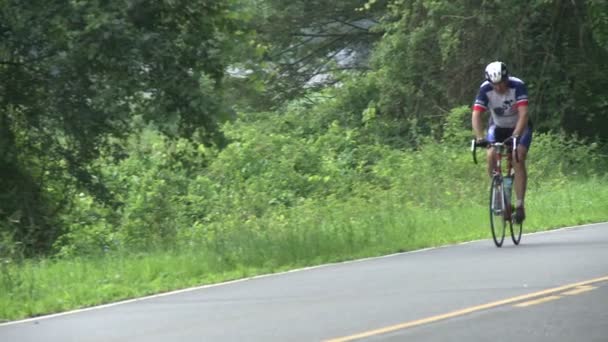Een fietser die zijn fiets in het platteland — Stockvideo