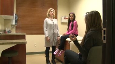 Genç bir hastaya bir doktor inceliyor