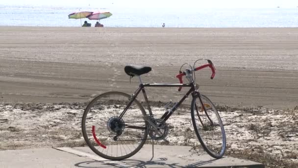 Duas pessoas sob guarda-sóis de praia na areia — Vídeo de Stock