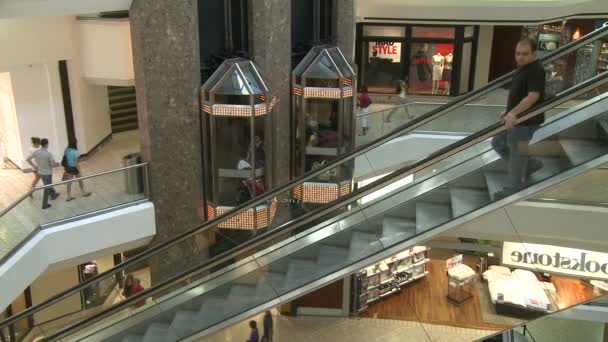 Shoppers in winkelcentrum in de buurt van roltrappen en liften — Stockvideo