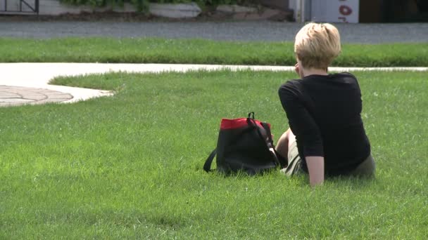 Vrouw kijken haar zoon spelen in een park (2 van 2) — Stockvideo