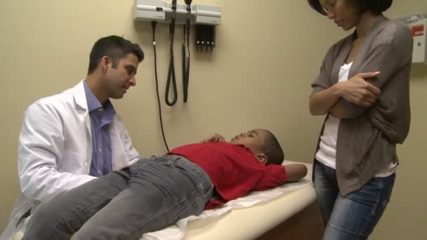 Врач осматривает молодого пациента — стоковое видео