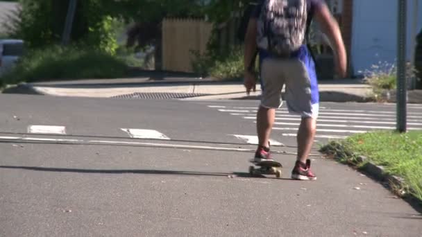 Chlapec jde ulicí na skate desky — Stock video