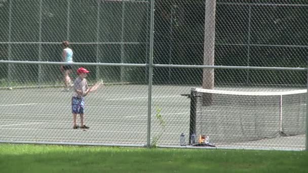 Fiú gyakorlatok visszatér egy tenisz szolgál (2-4) — Stock videók