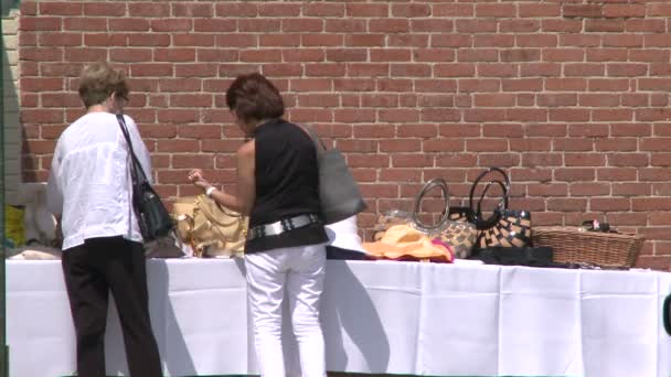 Twee vrouwen op zoek op tafel op de stoep te koop — Stockvideo