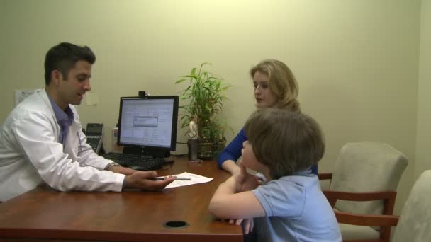 Médico teniendo una reunión con una familia acerca de su condición médica — Vídeos de Stock