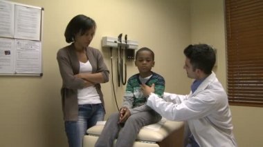 Genç bir hastaya bir doktor inceliyor