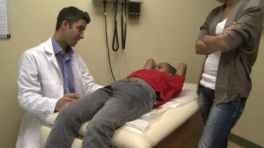 Genç bir hastaya bir doktor inceliyor