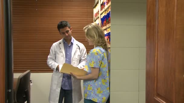 Arzt berät sich mit Arzthelferin oder Krankenschwester — Stockvideo