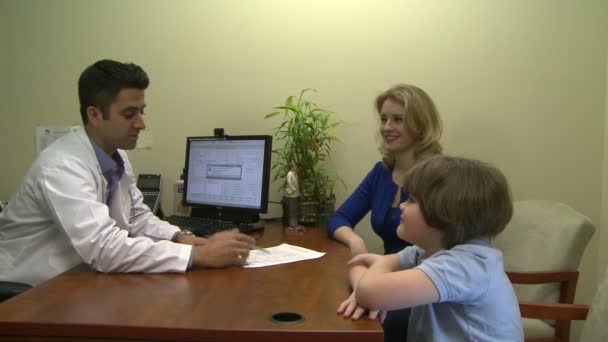 Médico teniendo una reunión con una familia acerca de su condición médica — Vídeo de stock