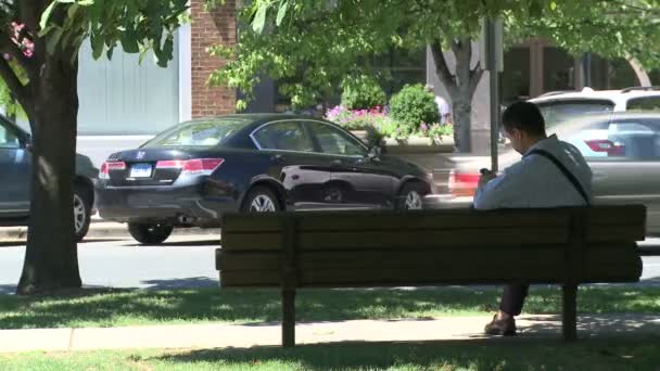 Homem sentado no banco do parque centro da cidade (2 de 2 ) — Vídeo de Stock