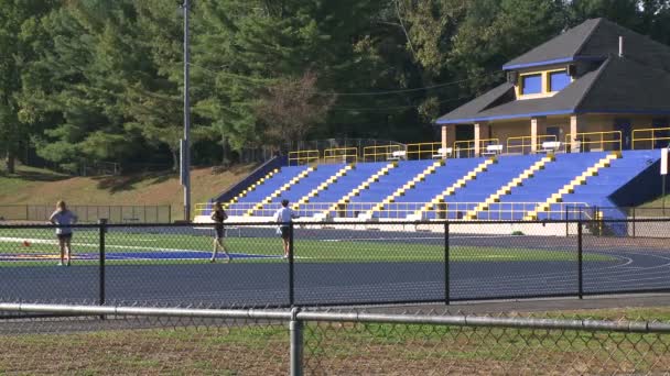 Pessoas que jogam frisbee no terreno desportivo — Vídeo de Stock