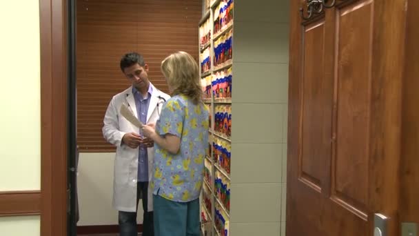 Arzt berät sich mit Arzthelferin oder Krankenschwester — Stockvideo