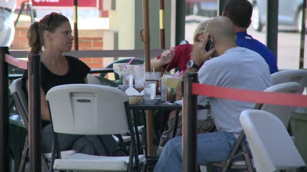 Man on cell phone while eating outside — Stock Video