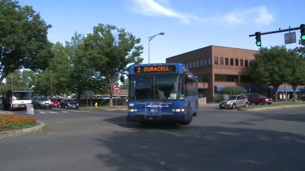 Местный автобус поворачивает на перекрестке — стоковое видео