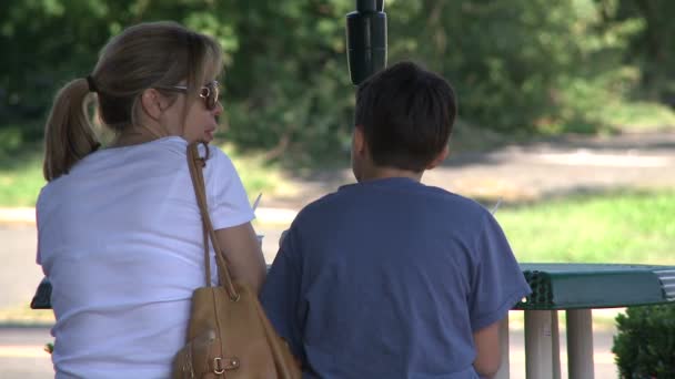 Mother and son enjoying ice cream at outdoor cafe — Stock Video