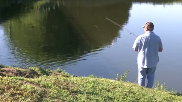 Мужчина рыбачит на реке — стоковое видео