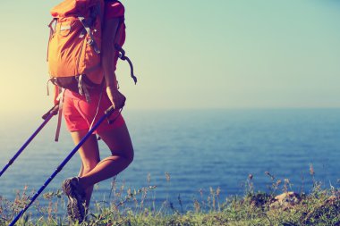 Sahil dağ izinde yürüyen genç bir kadın backpacker