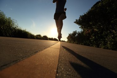 gündoğumu sahil yolunu üzerinde çalışan genç fitness kadın
