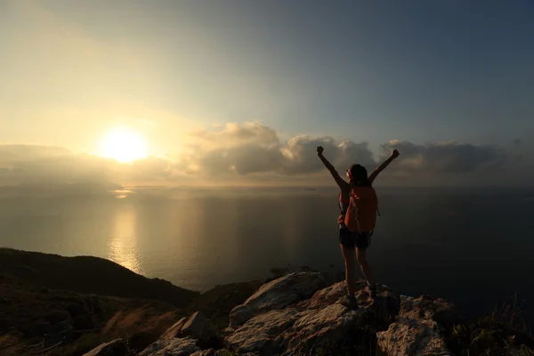 Torcendo jovem mulher no pico da montanha — Fotografia de Stock