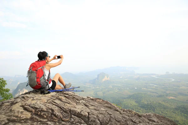 Kvinnan backpacker tar foto på berg — Stockfoto