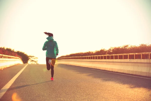 Mulher fitness na estrada do nascer do sol — Fotografia de Stock